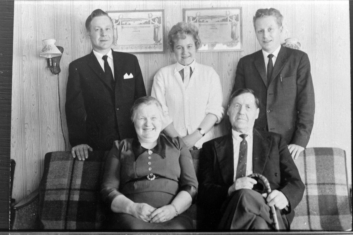 Familieportrett av familien Tømmerås, tatt i stue.