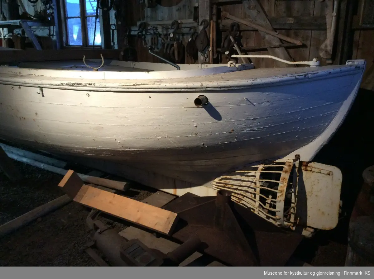 Hvit malt kravellbygget båt med  motor. og festeanordninger til 4 årepar.