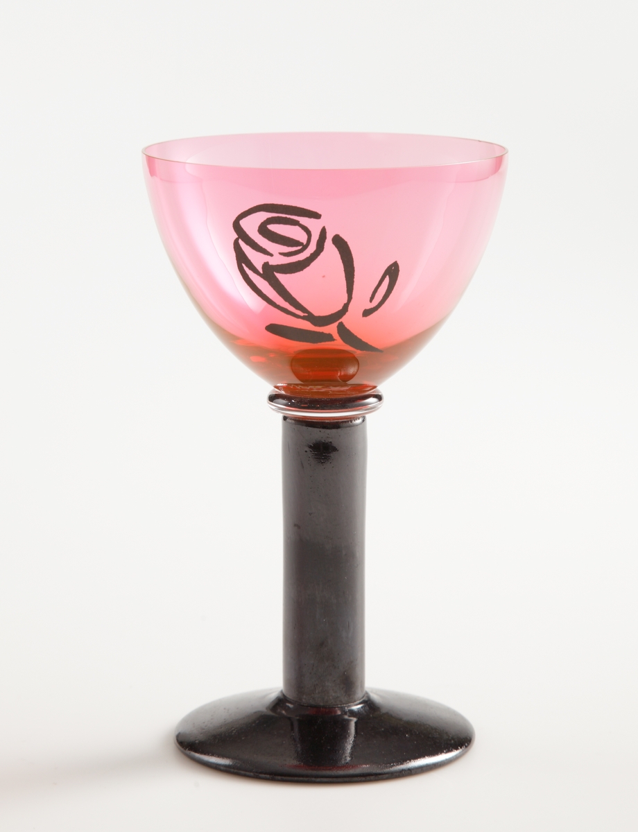 Vinglas "Rosé". Kupa i rosa med tryckt dekal i form av en svart ros, svart stolpben och svart fot.