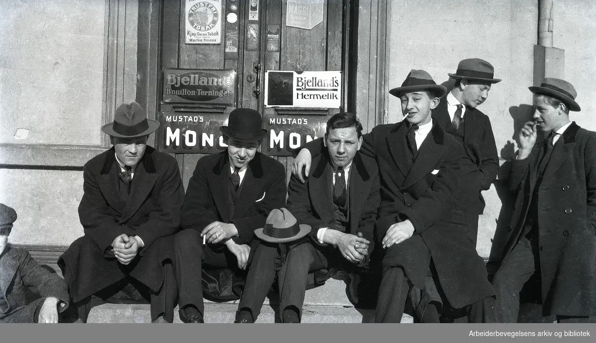 En gruppe unge menn samlet på trappa utenfor kjøpmann Gullkunnerud & Co i Enebakkveien 34 på Vålerenga. 1920-tallet.