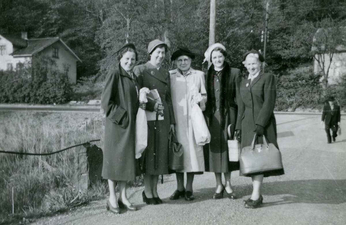 Fem uppklädda kvinnor står på Torrekullavägen (riksgränsen) i Torrekulla - gränsen mellan Mölndal (Fässberg) och Kållered, år 1953. De var sömmerskor från Bergströms Herrekipering i Göteborg och arbetskamrater till Bror Pettersson som har fotograferat. I bakgrunden ses Gamla Riksvägen. Till vänster ses Lilla Alvered "Korkskärarns" hus och till höger ligger familjen Stens hus som tillhörde Kållered.