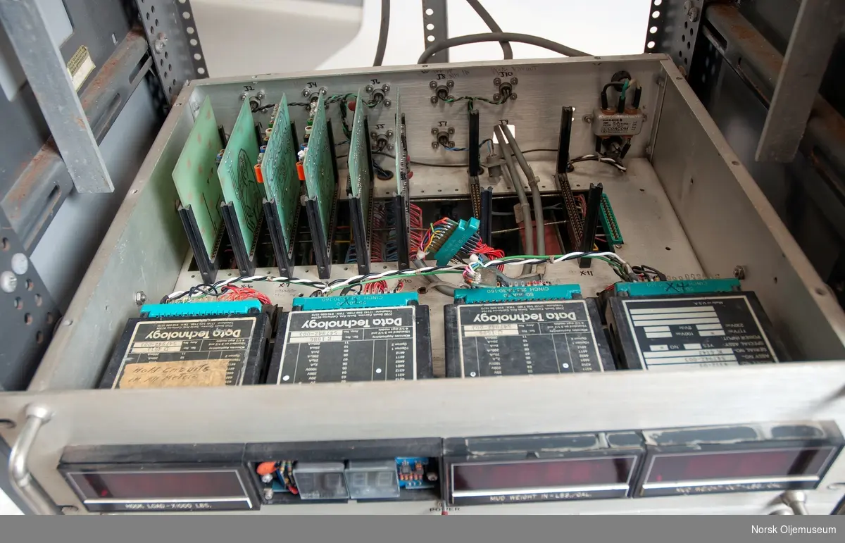 Kabinett med uttrekkbare skuffer som inneholder elektroniske komponenter. Skuffene har digitale avleservinduer foran.