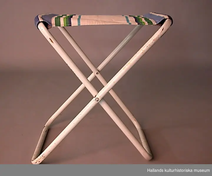 Campingmöblemang bestående av bord och fyra stolar. Bordsskiva av blåmålad masonit. Bärhandtag på bordet. Hopfällbart. Förvaras i originalkartong med texten: ORIGO camping.