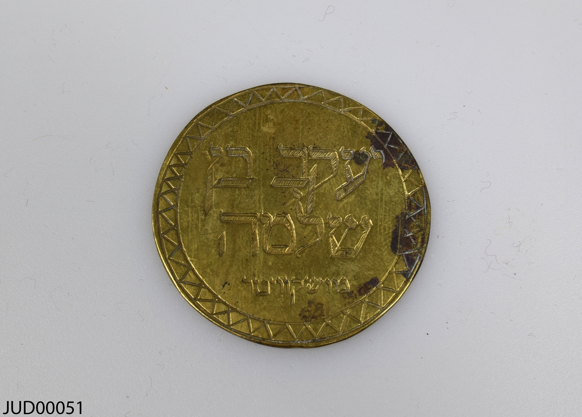 Två stycken bronsmynt. Det ena myntet är dekorerad med en vas samt hebreisk text, medan det andra myntet endast är dekorerat med hebreisk text. Båda är mycket tunna.