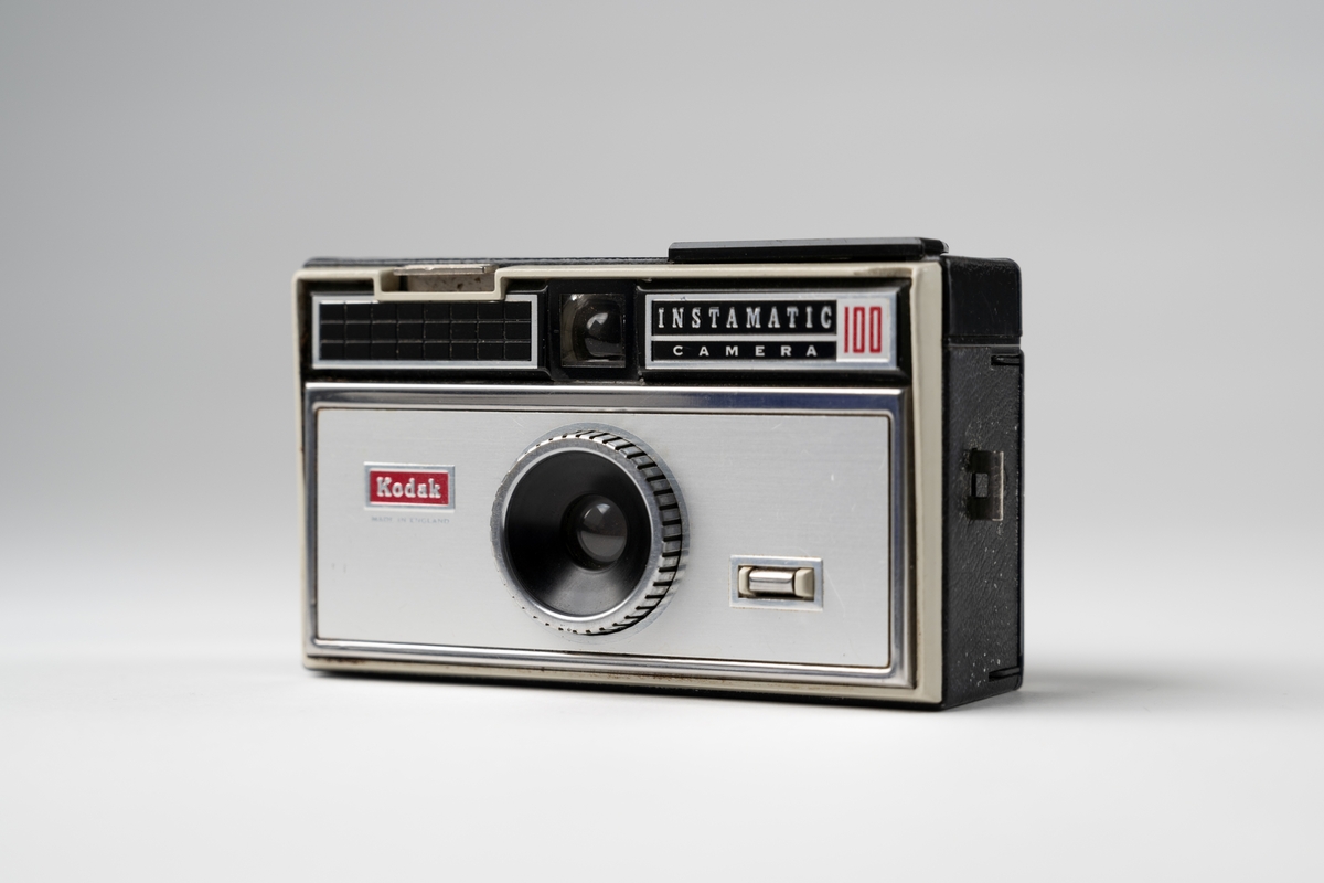 Kamera, Instamatic 100 av märket Kodak för filmkassetter. Av grå metall och svart konstläder. Öppning på baksidan, sikthål upptill i mitten fram och uttag för blixt på ovansidan.