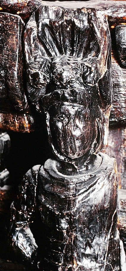 Skulptur föreställande en mansfigur i rustning. På huvudet förefaller figuren bära en plymagerad hjälm med krona. Hjälmen hålls på plats genom ett brett hakband. Bakom huvudet syns ett stort snäckskal. Rustningen verkar vara av så kallat romerskt skenpansar, lorica segmentata, med horisontellt placerade "metallskenor",  vilka täcker bröst och mage. En mantel är draperad i rika veck över bröstet.

Figurens huvud är vridet något åt vänster medan kroppen i övrigt är riktad frontalt. Kroppstyngden vilar på vänster ben, medan höger ben hålls något böjt. Figuren står på en sockel, vilken pryds av en maskaron.

Upptill är bakstycket framdraget i en kraftig, kvadratisk "huvudplatta", med en kvartscirkelformad profil. Skulpturens baksida uppvisar tre snedställda, olika djupt liggande fält. Fälten, som utgör anliggningsytor, ger skulpturen en trappstegsformad profil.
Skulpturen är kraftigt sliten och skadad. Figurens bägge armar med vidhängande manteldelar saknas, liksom större delen av fötterna. Vänster del av bålen är kraftigt sliten, liksom ett parti av rustningens nederdel. Ansiktsdragen är till stor del utplånade. Sockeln är delvis mycket skadad, med mer än halva maskaronen bortbruten. På sockeln har det även funnits en namninskription, som dock är utplånad.

Text in English: A sculpture representing a male figure in armour. On the head is a plumed helmet and a crown held in place by a strap which goes under the chin, and behind the head is a large sea shell. The figure is wearing a Roman cuirass, lorica segmentata, with horizontally placed "metal bands", covering the chest and stomach. Across the chest are parts of the mantle which can be seen like a collar.

The body and legs face front while the head is turned slightly to the left. The body rests on the left leg while the right leg is slightly bent. The figure stands on a plinth which bears a mask.

The upper part of the back extends obliquely upwards in a powerful "head board". The back of the sculpture has three obliquely placed surfaces of different depths that are attachment areas. The surfaces make the sculpture look like a step-ladder in profile.
Most of the sculpture is badly worn and damaged. The figure''s feet and arms with any part of the mantle that was attached to them are broken off. The left side of the torso is very worn, as is a section of the armour. Most of the facial features are obliterated and the crown is fragmentary. The plinth is badly damaged with more than half of the mask broken off. The inscription that was on the label has worn away.
