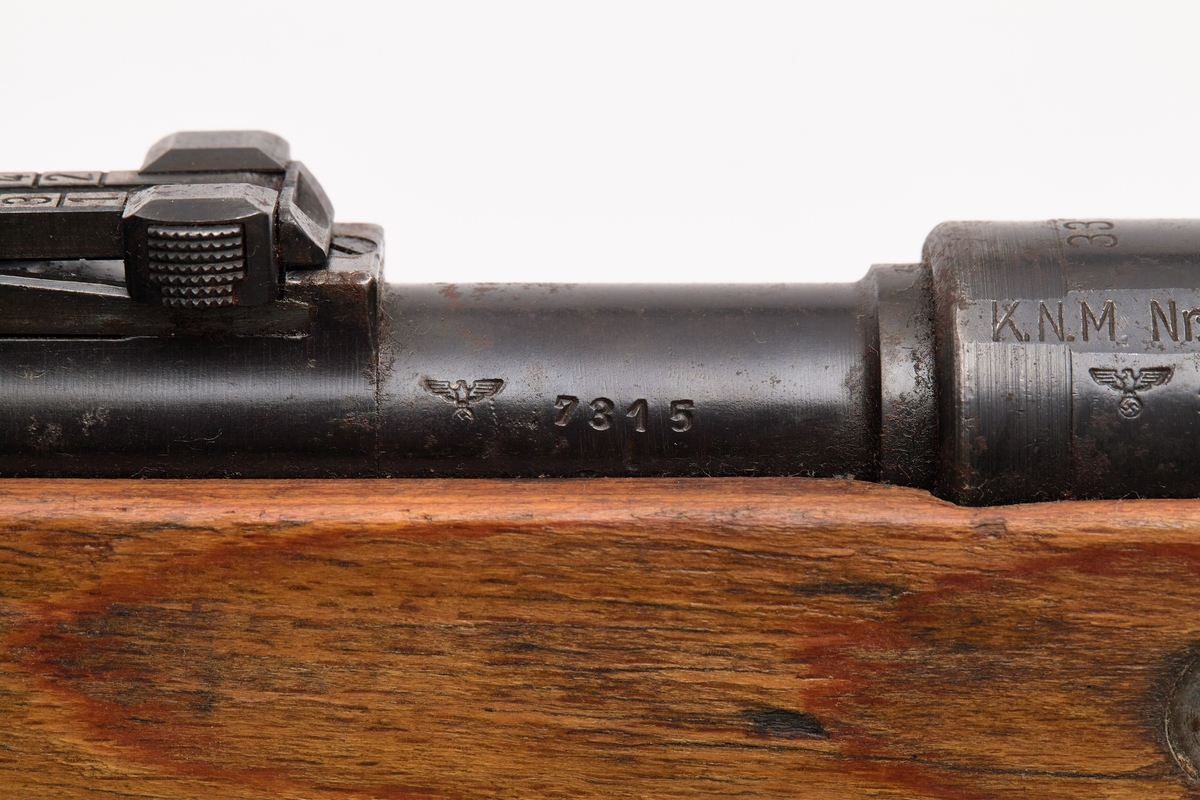 Mauser (a), bajonett (b) slire (c) og pussesett (d). En original og komplett Mauser kaliber 7.92, som var det vanligste våpenet brukt av den tyske armeen under 2. verdenskrig. I tillegg følger det med pussesett og bajonett med belteslire, men det mangler balg.