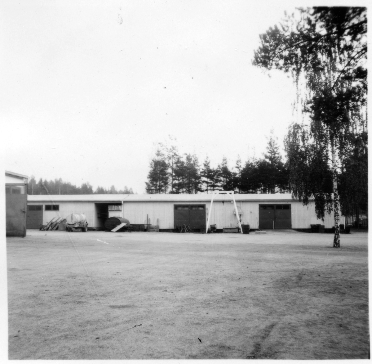 Vägstation D4, Katrineholm. Förrådsbyggnad. På garageplan skottkärror och luttunna.