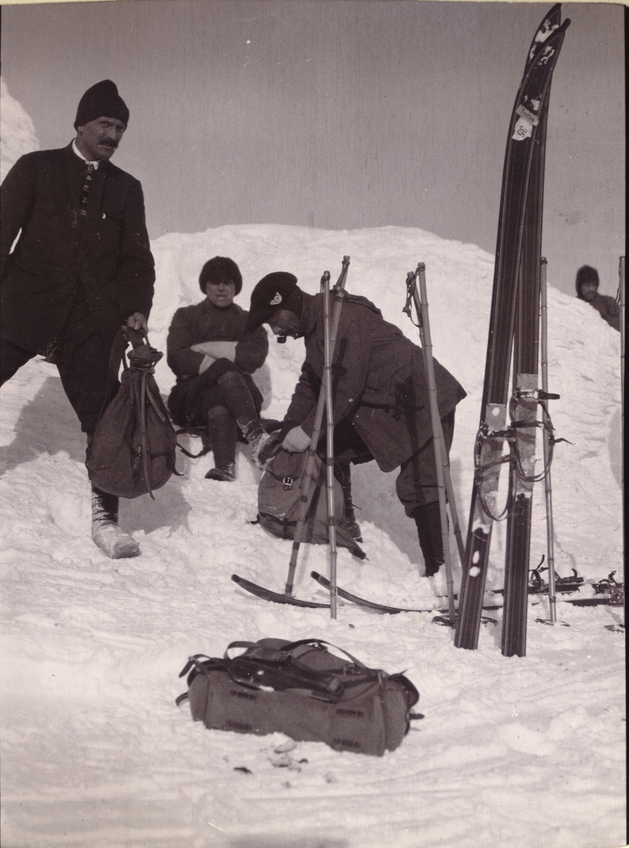 Tre skigåere, Giraud, Durban-Hansen og Gelinet, raster i snøen på toppen av Nautgardstind, på vei til Bessheim i Jotunheimen. Fotografert i mars 1908.