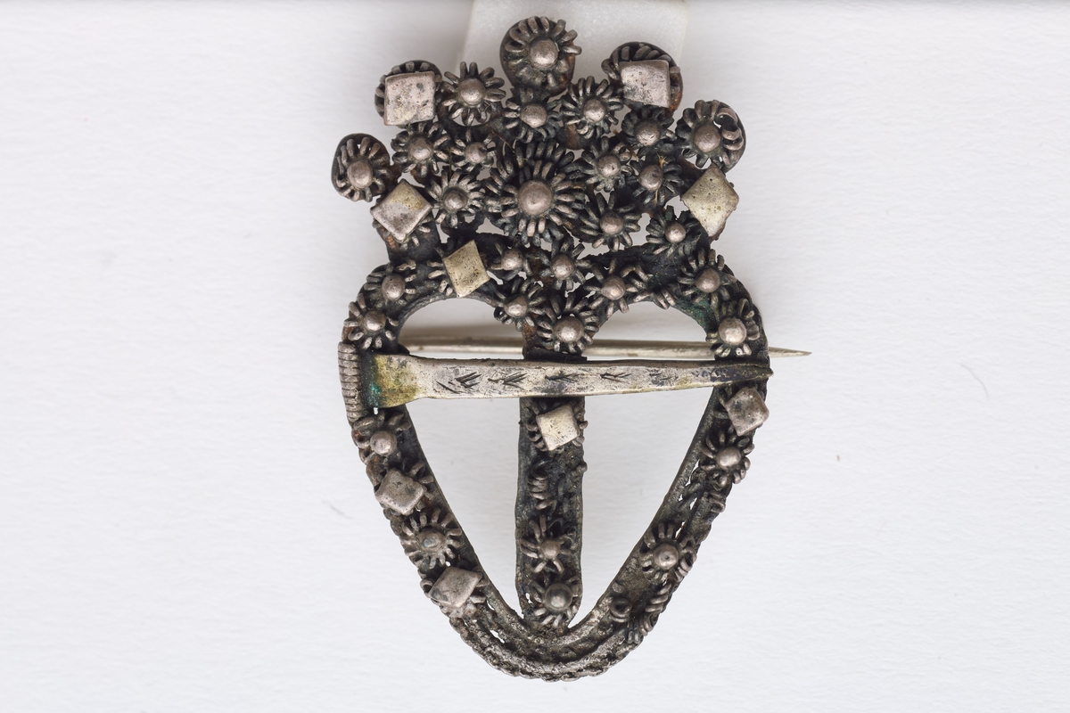 Sølja er hjerteformet med en krone av filligran.
