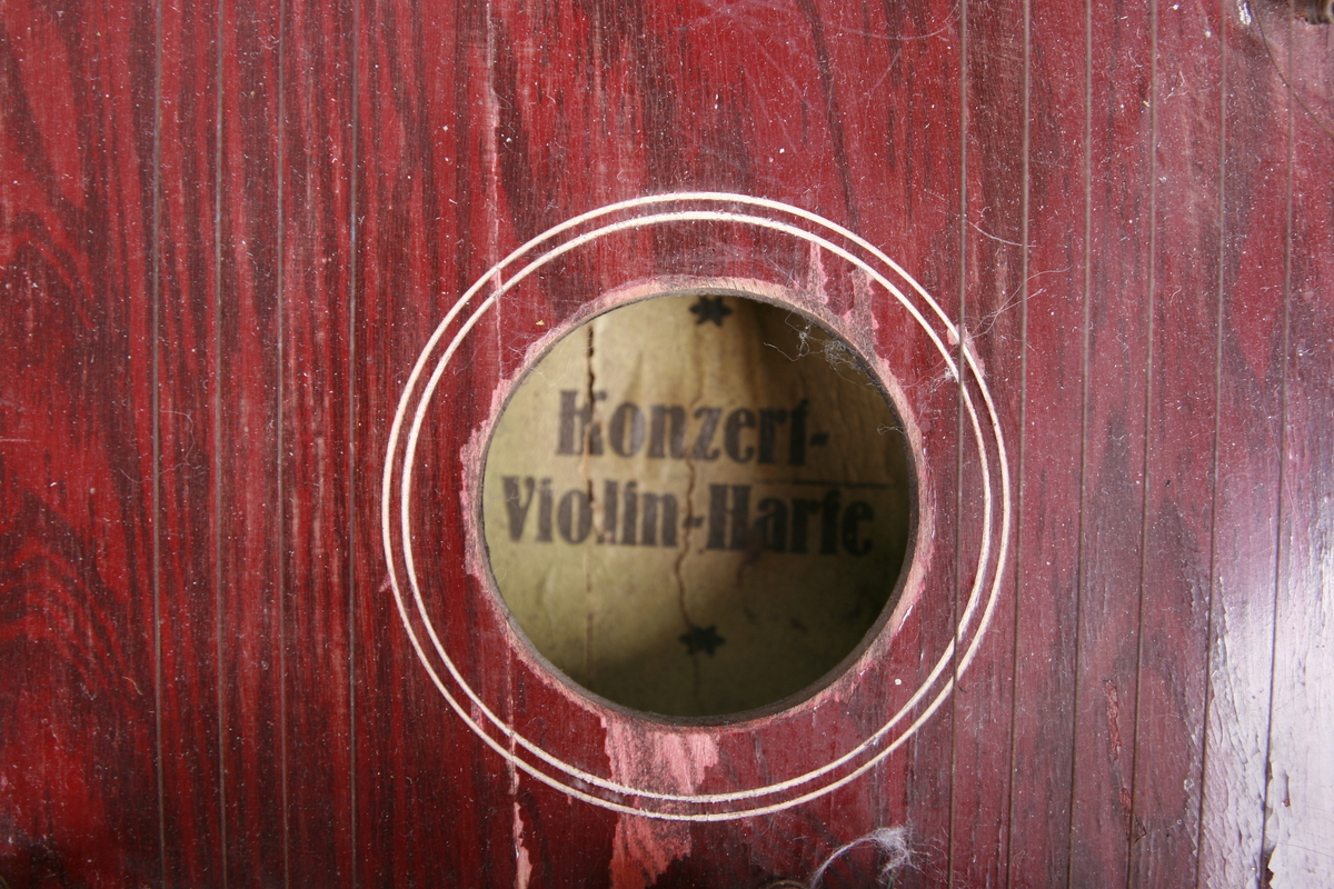 Rosemaling og påmalt innskrift «Harfen Zither», på korpus påmalt tonehøyder med floral dekorgirlande utenpå.