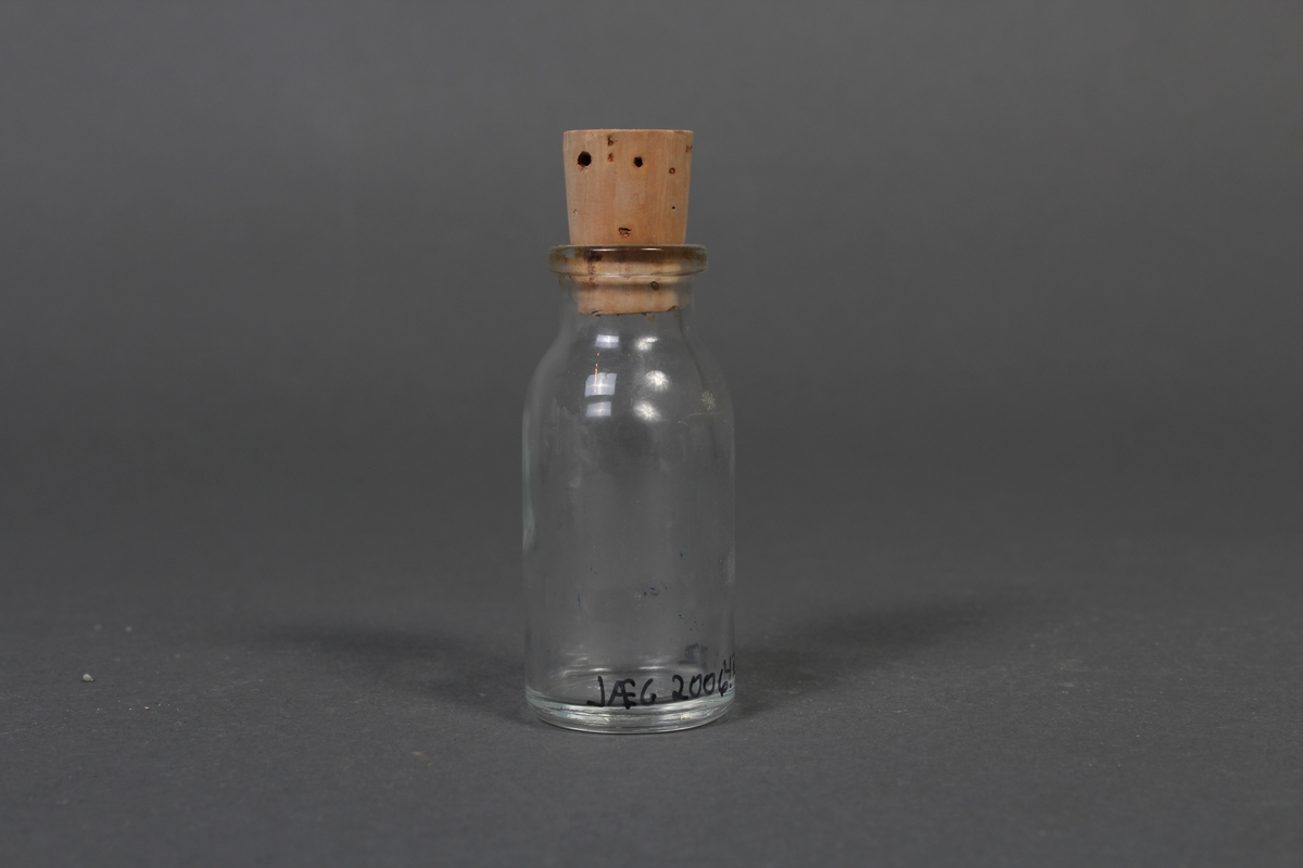 Liten flaske i klart glass, med kork.
Gjenstanden har vore brukt i samband med dyrlegearbeid på Jæren.
