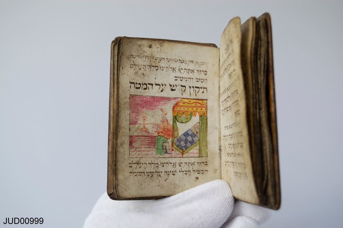 Handskriven liten bönbok med illustrationer och hebreisk text.