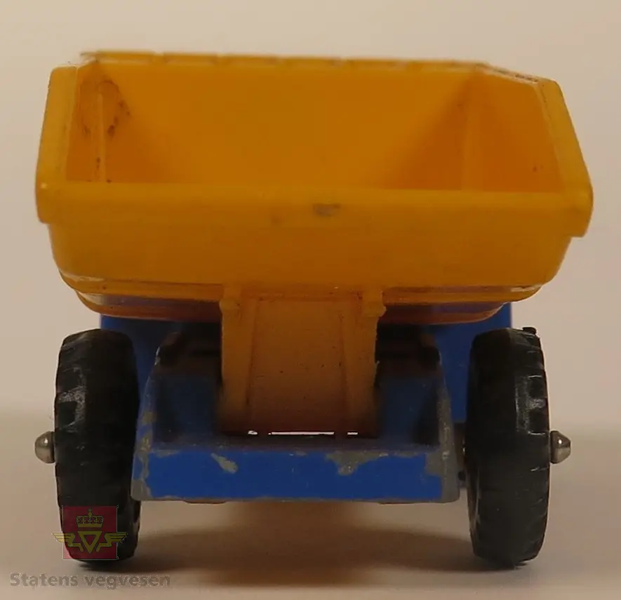 Hovedsakelig blå modell med gult lasteplan. Den er hovedsakelig laget av metall og lasteplanet er laget av plast. Skala 1:74.