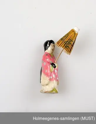 Liten japansk porselensdokke, kledd i rosa kimono. Fargene er påmalt og lakket.