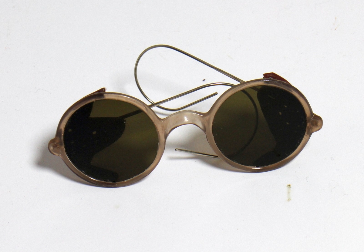 Solbriller med runde, mørke glas og brun innfatning, som har tilhøyrt diktaren Henrik Rytter (1877-1950). Solbrillene har vore oppbevart på Henrik Rytter sin eigedom, "Rytterhaugen".