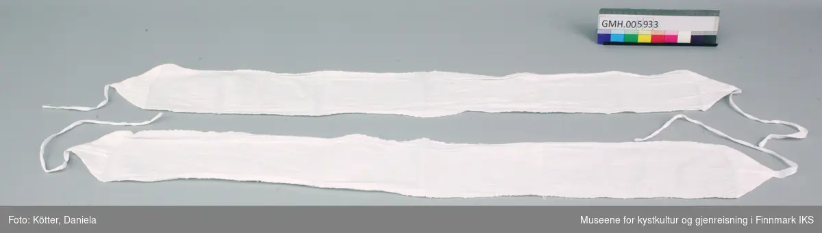 Disse to bind består av lange striper hvit, vevd bomullstøy som er sydd til trekanter i endene. I spissene er det påsydd bomullsbånd. 
I lengda er binden sammensydd av to tøybiter slik at det blir tydelig, at det opprinnelige tøystykket ikke var lengre enn 70 cm. Kantene er sydd med rett tråklesøm. Trekantene er sydd om med geitesøm.