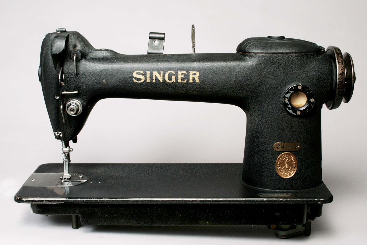 Symaskin, i svartlackerad metall, med blanka detaljer. 1-nåls, för raksöm. Märkt: SINGER, 241-12, Nr AG 599419. Proveniens Eiser AB, Borås.