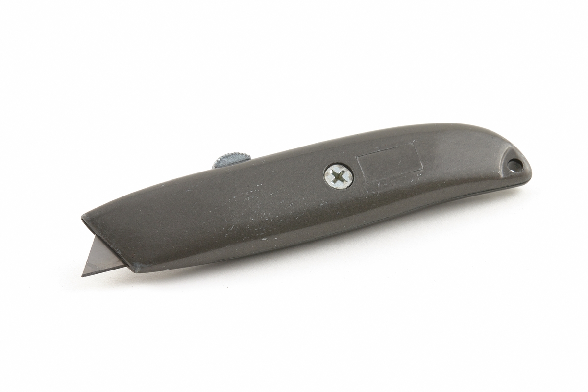 Mattkniv med utbytbart trapetsformat knivblad i metallhölje. Knivbladet flyttas ut och in ur höljet med en knopp. Stjärnskruv håller ihop höljet.