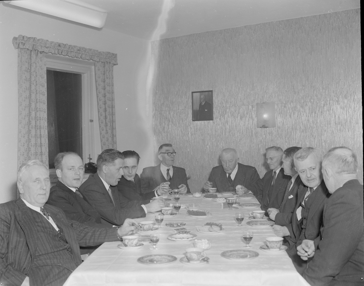 En gruppe menn er samlet til kake og en drink i slakteriet på Eie før åpning.