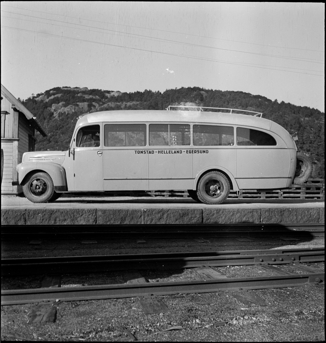 En buss av merket "Ford" ved jernbaneskinner i Egersund. Bussen gikk i ruta Tonstad-Helleland-Egersund.