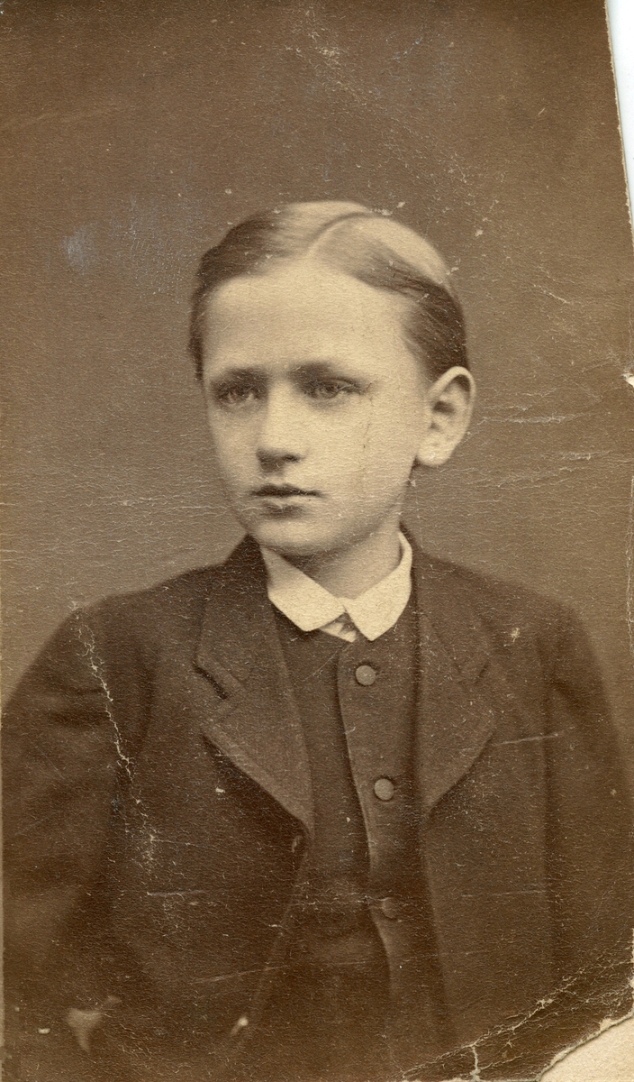 Porträtt av en kostymklädd pojke.