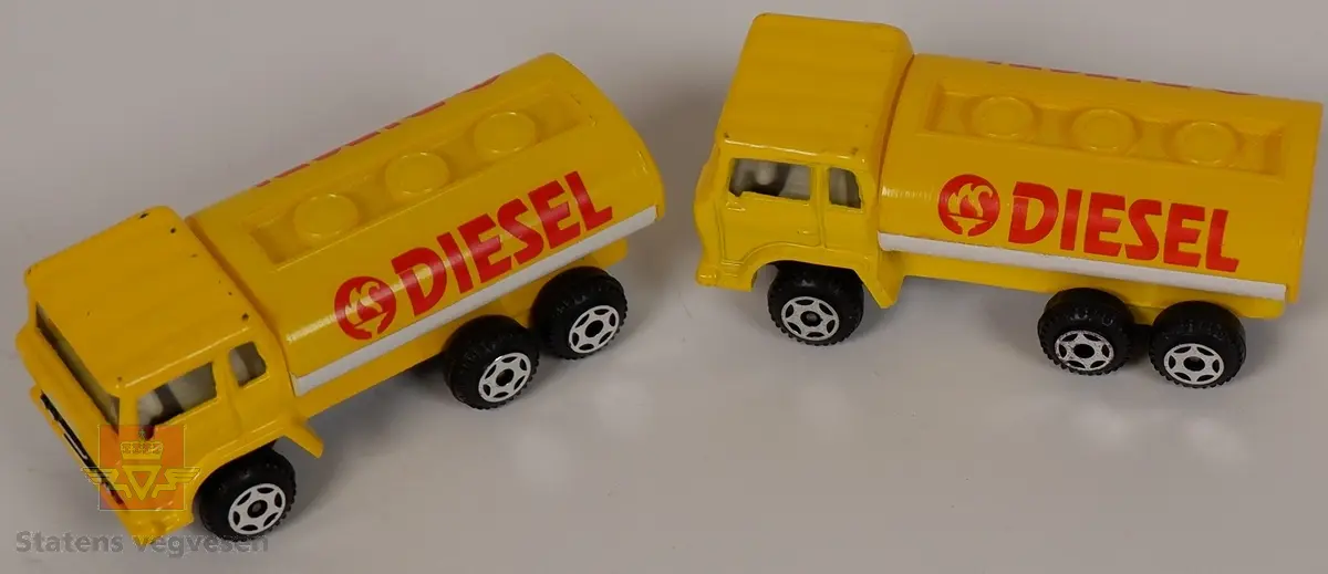 To miniatyrmodeller av lastebil med tank. Modellene er laget hovedsakelig i metall, med understell, hjul og tank i plast. Fargen er gul og hvit med påskriften DIESEL på begge sider av tanken.