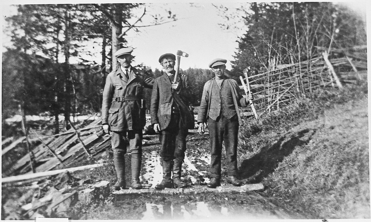 Mannskap for tømmermåling i Vasslia,  omkring 1925. Fra venstre: tømmermåleren som er ukjent, Gullik Emmerud og Engebret Flågan.