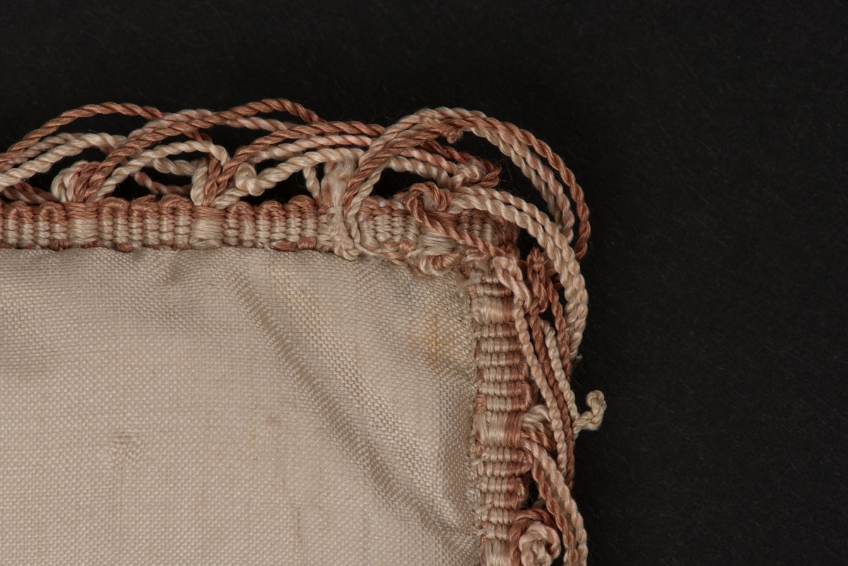 Käpp av guld och krycka av silver, uppfästa på vitt siden med pärlbroderier. 
Sidenet är i två lager med fyllning. Kanten är dekorerad med sidentråd i vitt och brunt. På framsidan ovanför kryckan och käppen finns en pärlbroderad rosett i två färger, vinrött och rosa.
På framsidan sitter en fastsydd etikett med följande text:
"Käpp och Krycka Brudgåfva 1820 sk. af Öfverstinnan Örn".