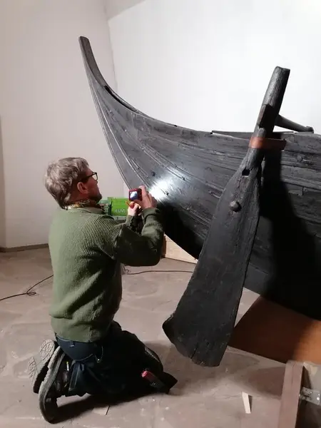 Båtbygger ved Norsk Maritimt Museum, Lars Stålegård, undersøker akterstevnen på vikingtidsbåten fra Gokstadhaugen.