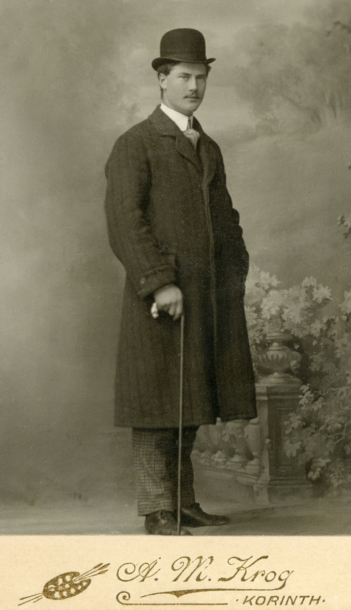 Portrettfoto av mann med hatt og stokk