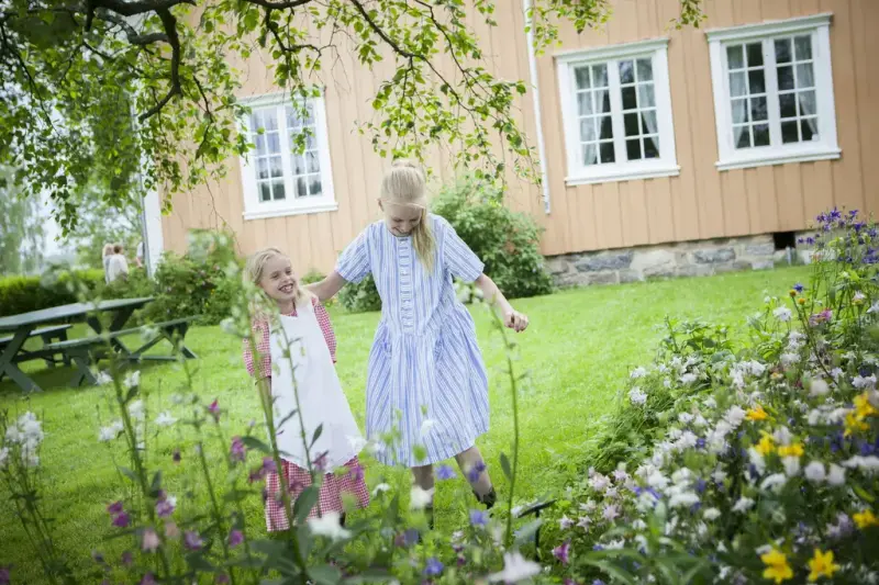 Bildet viser to jenter som leker i hagen.