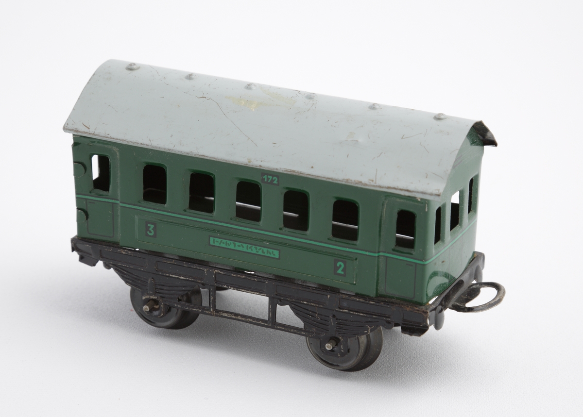 Passagerarvagn tillhörande tågset i tre delar, tillverkad i pressad tunnplåt. Vagnen består av ett välvt gråmålat tak, grön vagnskorg och svart underrede, samt försedd med fyra hjul. På vagnssidorna finns målade nummer som anger 2:dra resp. 3:djeklass.
Inskrivet i huvudkatalog 1982.