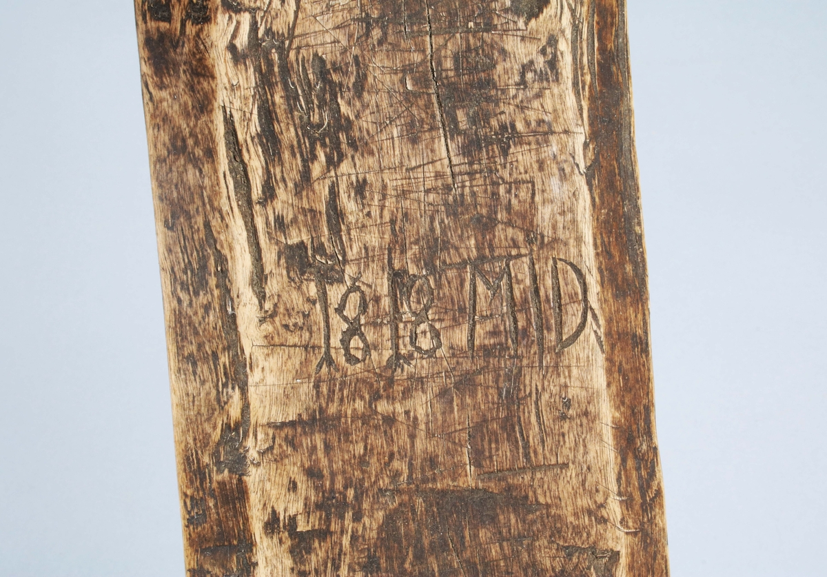 Mangelbräde i brunbetsat trä. Handtag och bräde skuret i ett stycke. Översidan utan ornering samt skuret: "1818 MID". Kanterna fasade. Rundad framtill. Bruks- och färgslitage.

Mangelbräde eller kavelbräde är ett redskap av trä som använts för mangling av textilier. Mangelbrädet användes tillsammans med en kavel, en slät rulle av trä. Den textil som skulle manglas, rullades upp på kaveln, på ett bord eller annat slätt underlag. Under hårt tryck, rullades kaveln med hjälp av mangelbrädet, fram och tillbaka över bordet. (Wikipedia)