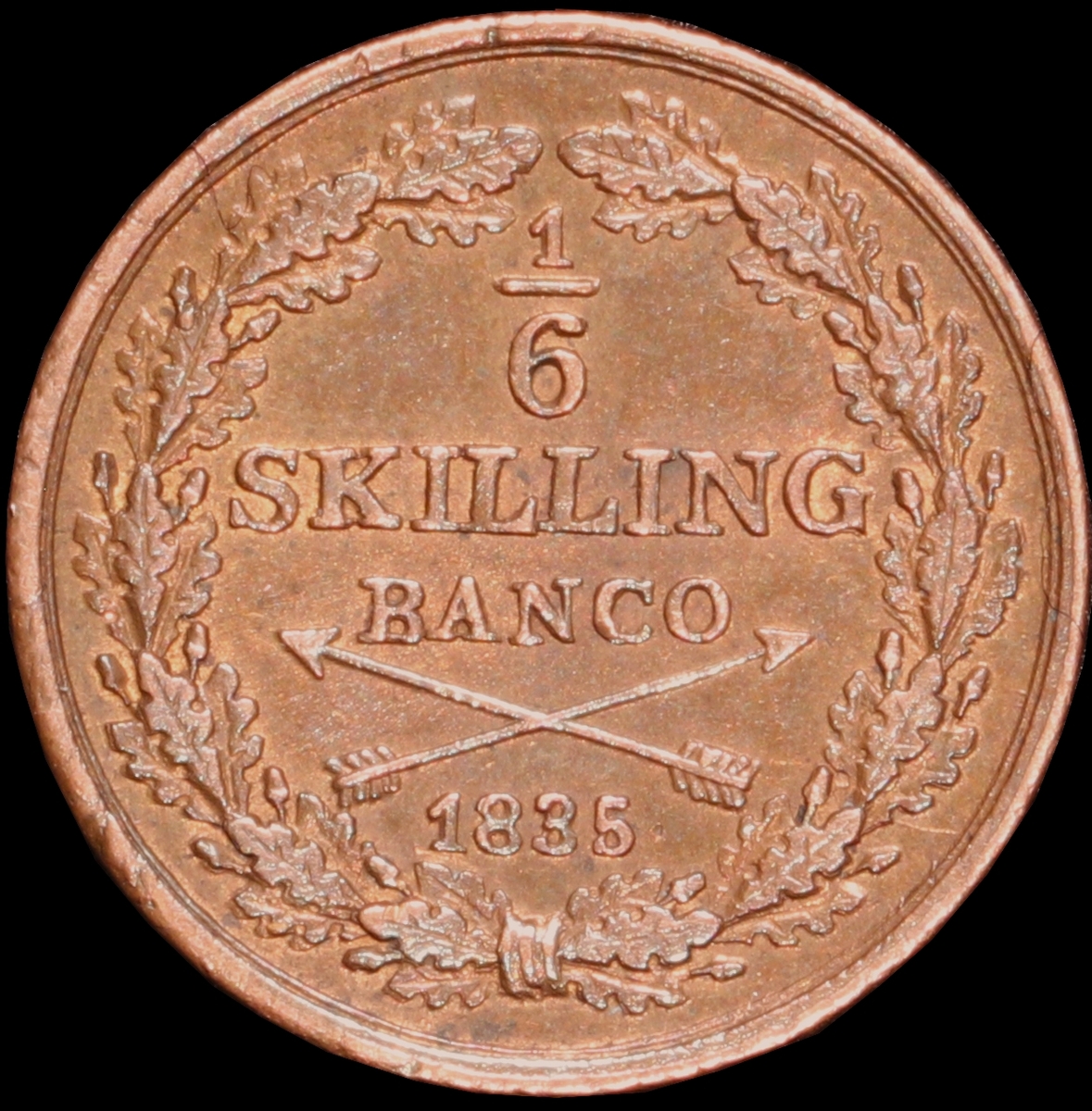 Mynt med valören 1/6 skilling banco. Åtsidan har Kung Karl XIV Johans monogram, tre kronor kungens valspråk. Frånsidan visar valören, två korslagda pilar samt en växtkrans.