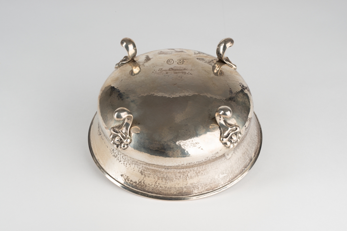 Bolle i sølv med 4 dekorerte føtter ("løveføtter"). Kort, markert korpus med høy kant over.