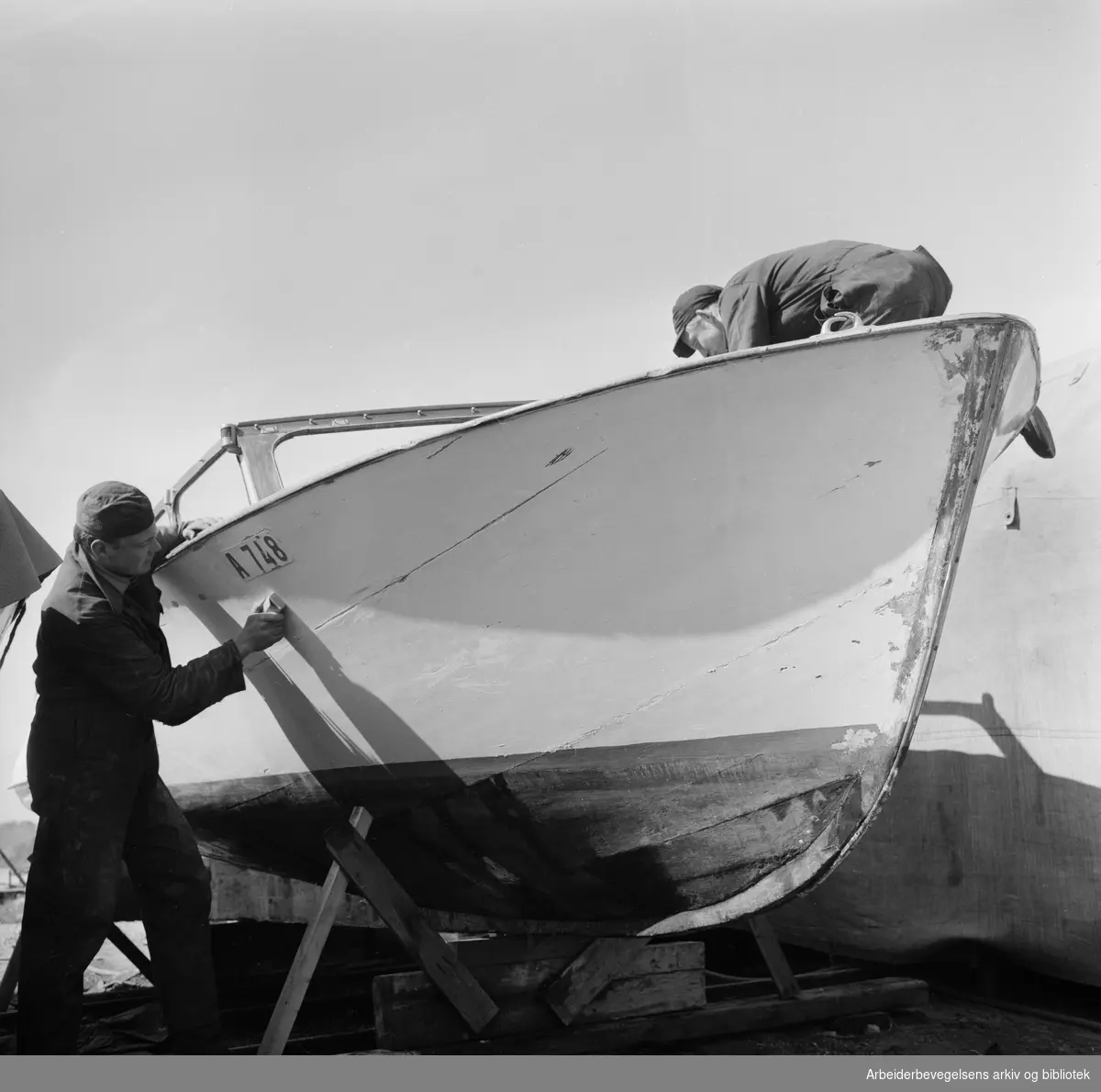Trebåter i vinteropplag. Bjarne Jacobsen og Birger Holmsen pusser motorbåt. Karenslyst - Sjølyst. Mai 1960.