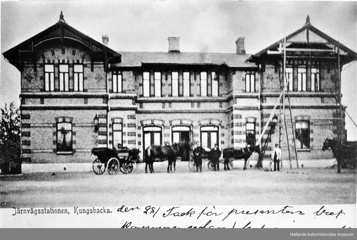 Brevkort, "Järnvägsstationen, Kungsbacka." Framför byggnaden står några hästekipage och på stationens högra risalit pågår byggnadsarbete med resta stegar.