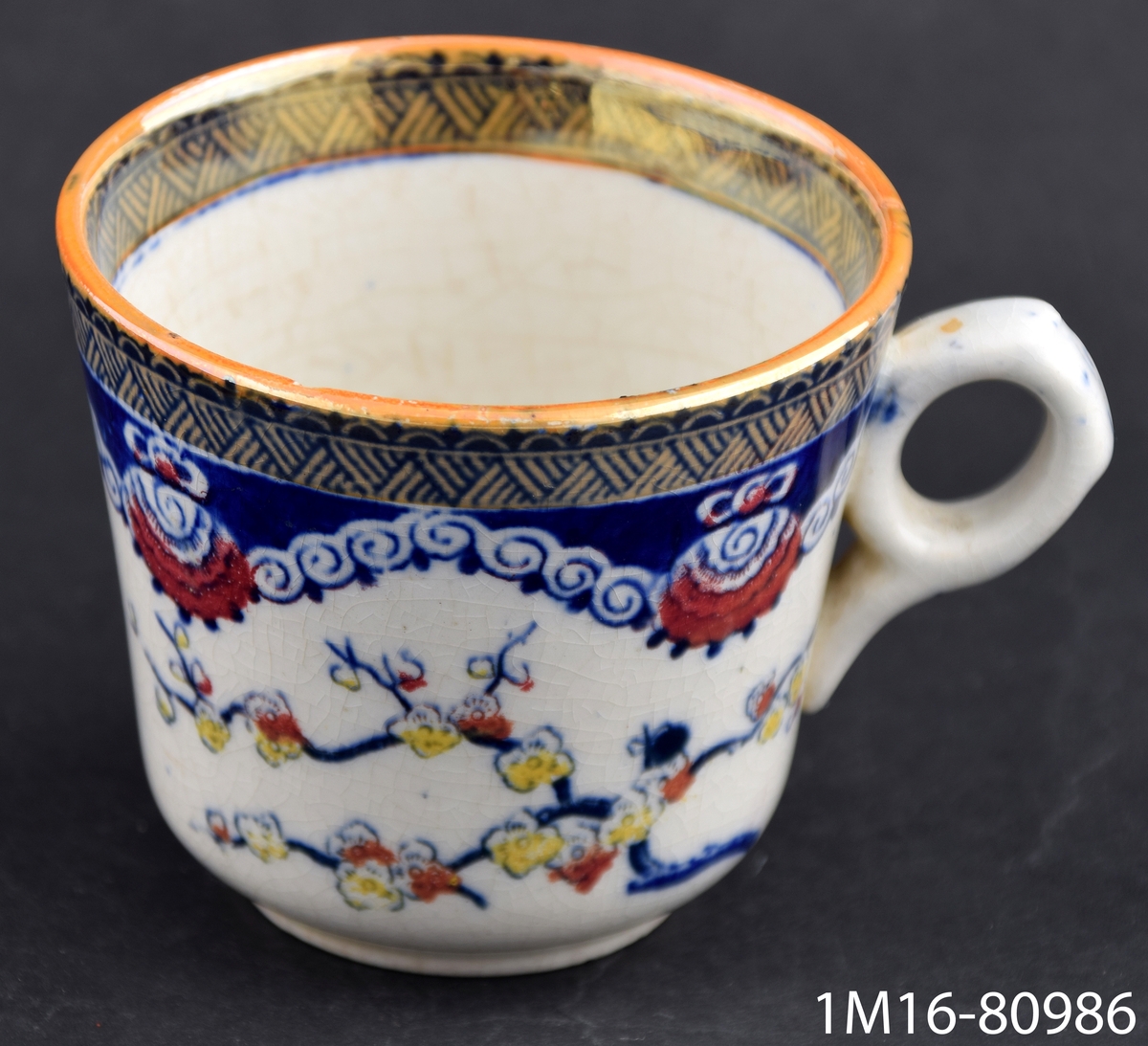 Kaffekopp med fat, mångfärgad tryckt och handmålad dekor i blått. gult, orange lyster och rött. Dekornamn Kina.