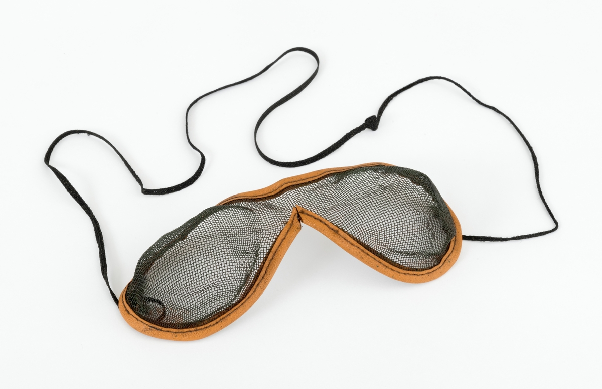Brille, vernebrille, som brukes for å hindre at flissprut fra motorsaga treffer øynene. Vernebrillen består av en finmasket metallnetting som er festet i en innfatning av lær. Det er sydd fast en snor,  brillesnor, til innfatningen, slik at vernebrillen kan henge rundt brukerens hals når den ikke benyttes.