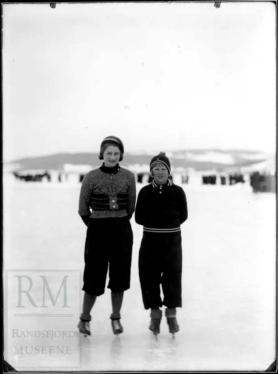 To jenter med skøyter står ute på isen, Randsfjorden