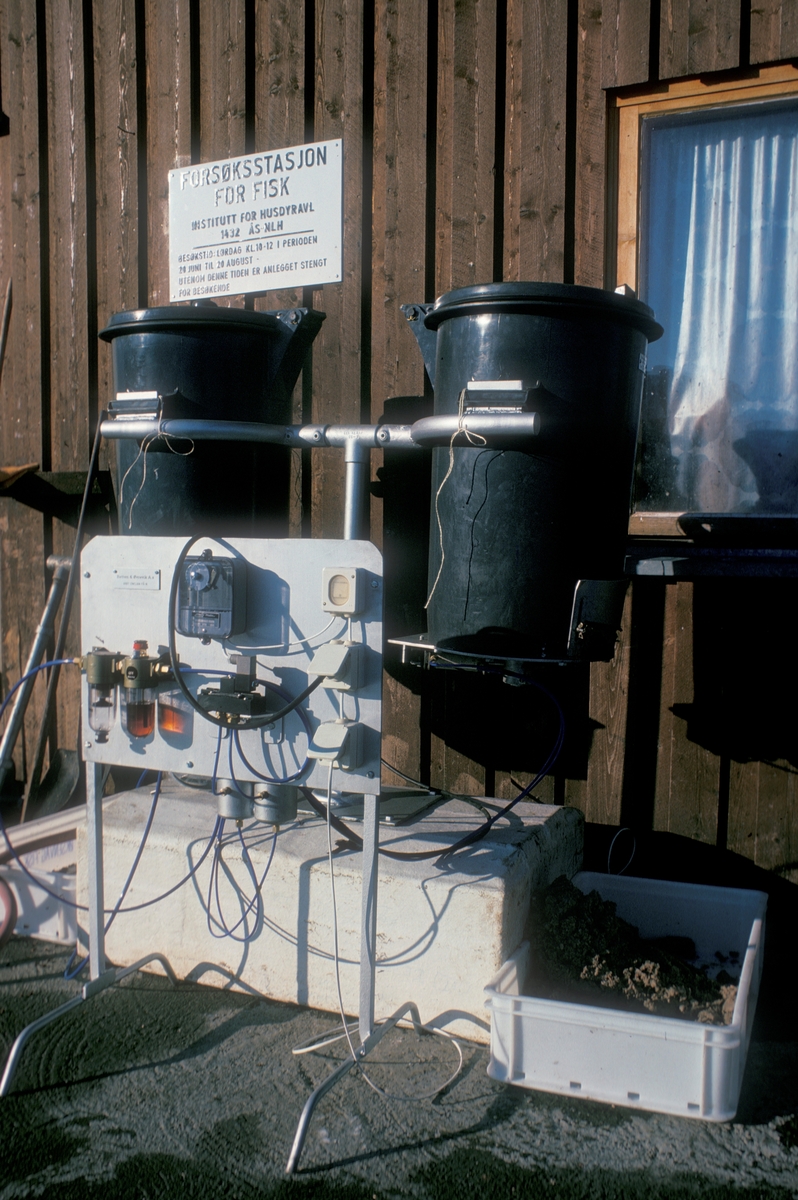Bilde fra Akvaforsk sitt forsøksanlegg på Averøya. Dette er en fôrautomat som står til utprøving. Det ser ut som fôret faller ned i en  kasse på hver side.