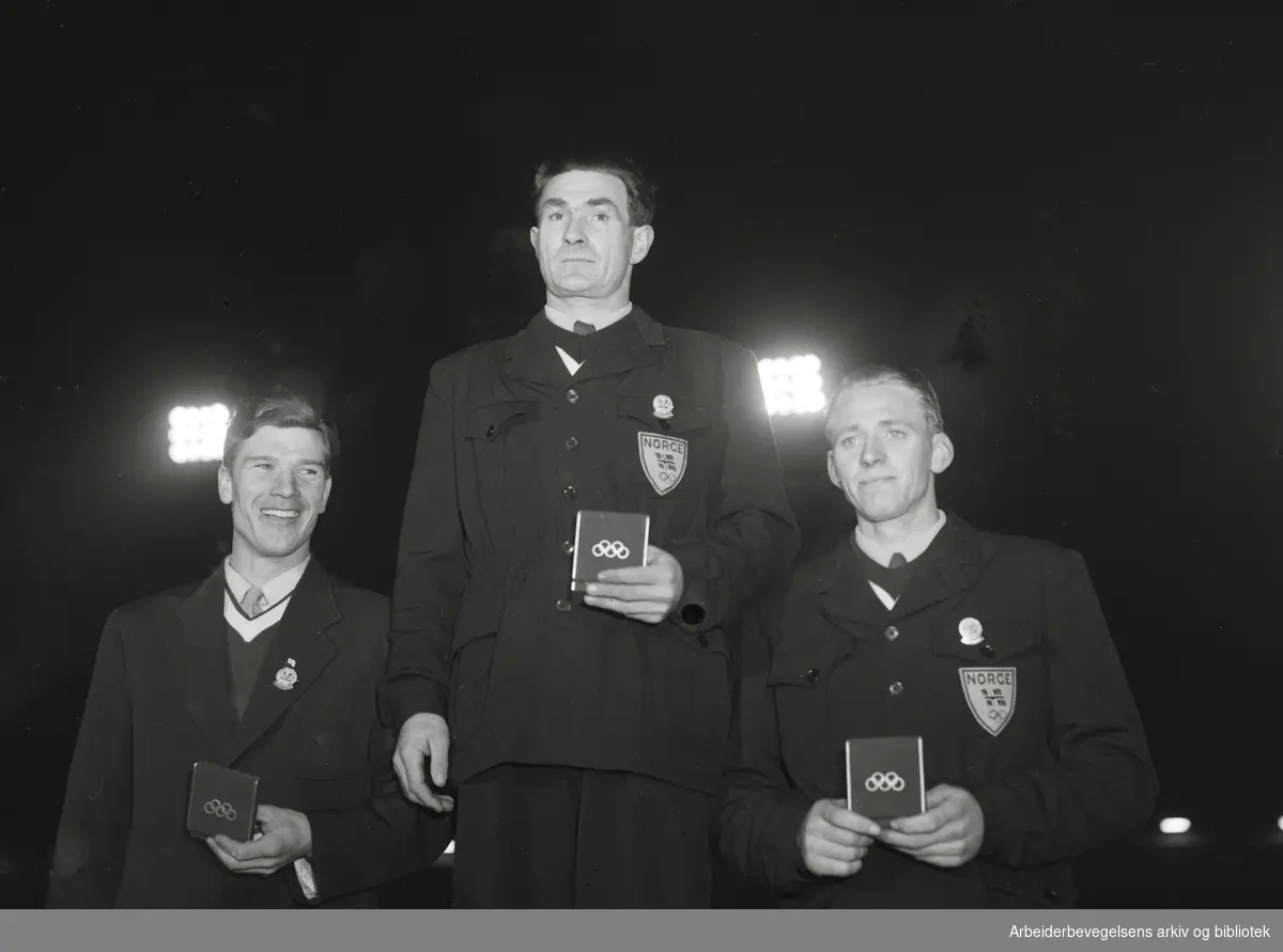 Olympiske vinterleker i Oslo 1952. Premieutdeling for kombinerte renn. Fra venstre: Heikki Hasu, Finland, Simon Slåttvik (Gullmedalje) og Sverre Stenersen, begge fra Norge.