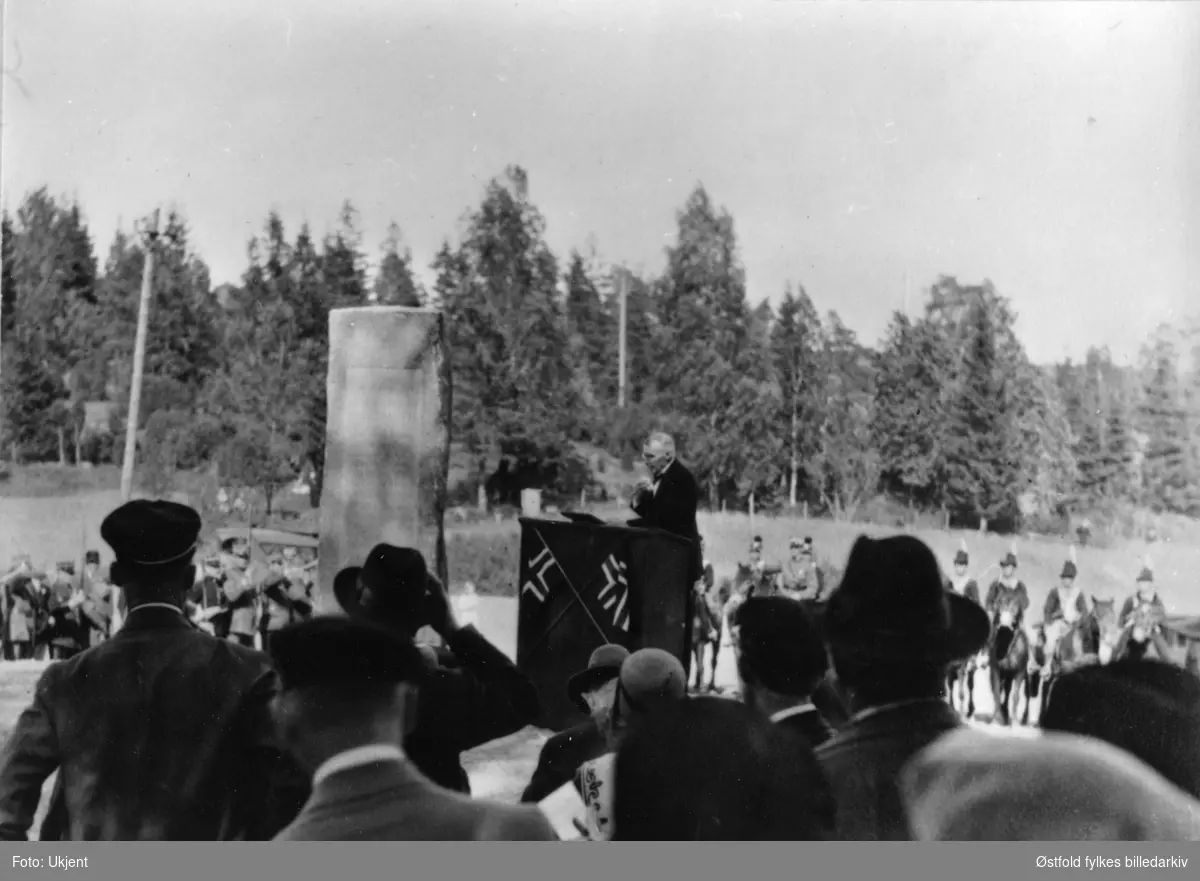 Fra avdukingen av Oluf Davidsen Ulvetangens bauta 1. juni 1930 på Klemsdal gård i Varteig. Olav Spydevold taler, musikkorpset "Klang" var med. I bakgrunnen skimter vi utkledde kavalerister (utlånte uniformer fra Kavaleriets befalskole i Oslo).