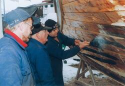 Tre menn arbeider med restaureringen av M/K "Folkvang".