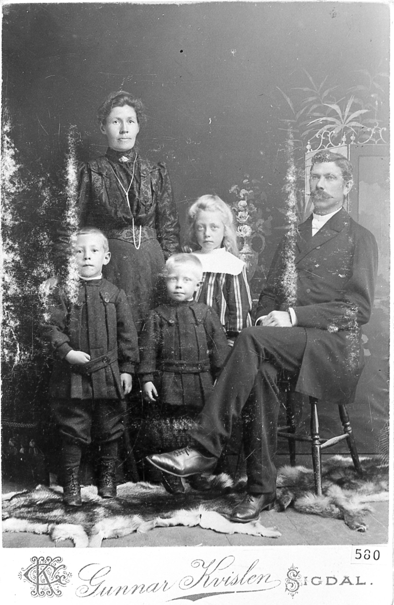 Familieportrett. Ole Olsen Kolsrud med hustru Kristine N. Kolsrud og tre barn. Atelierfoto av Gunnar Kvislen, Sigdal, omkring 1900-10.