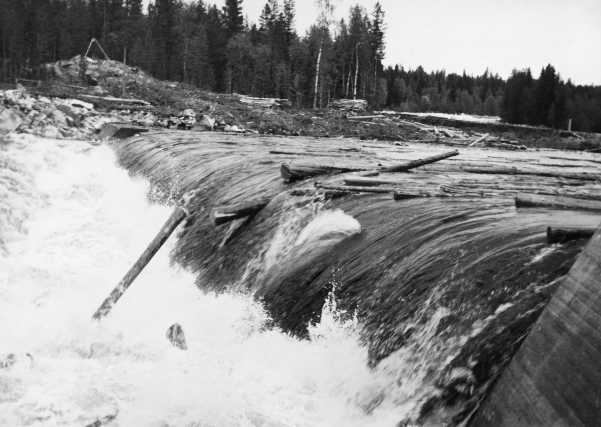Kvernfallet i elva Søndre Osa, Åmot, Hedmark. Tømmer på vei gjennom dammen.