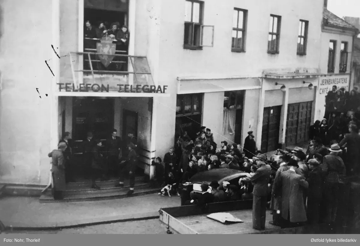 Frigjøringsdagene i Halden i mai 1945, etter andre verdenskrig.Telefon og telegraf.Jernbanegatens cafe og restaurant til høyre. Grensepolitiets (Grepo) kontorer i Telegrafbygningen  blir besatt 9. mai av en milorggruppe.