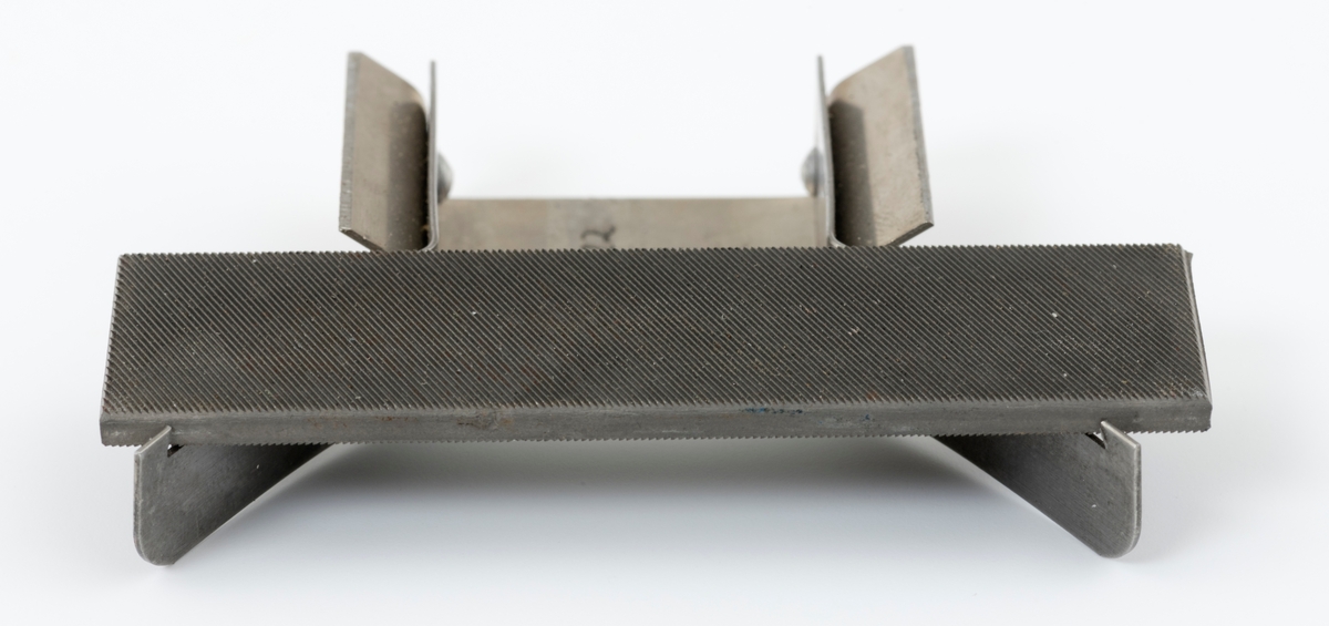 Fileverktøy, (se også SJF.01358), av typen "Woxna" er et kombinasjonsverktøy for filing av sagblad. Verktøyet kan brukes til tannavretting, sideskjerping og justering av høveltenners tannhøyde. Verktøyet består av en metallholder med to utstående "vinger". I disse vingene er det montert en kort flatfil, 7,6 centimeter lang. Flatfila er montert i holderen fra fabrikk. Vingenes fjærbelstaning holder fila på plass. Det er, som nevnt, mulig å bruke verktøyet til justering av høyden på tennene på høveltannede sager, men da kreves det at man bruker særskilte plater, maler, i holderen. Slike plater følger ikke med dette verktøyet (til  SJF.01358 er det slike plater).
For informasjon om bruk av fileverktøyet se vedlagt fil under fanen referanser til filer.