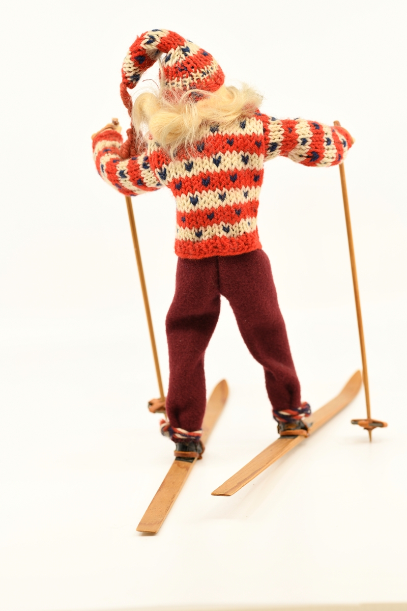 Dukke som forestiller jente med ski på beina